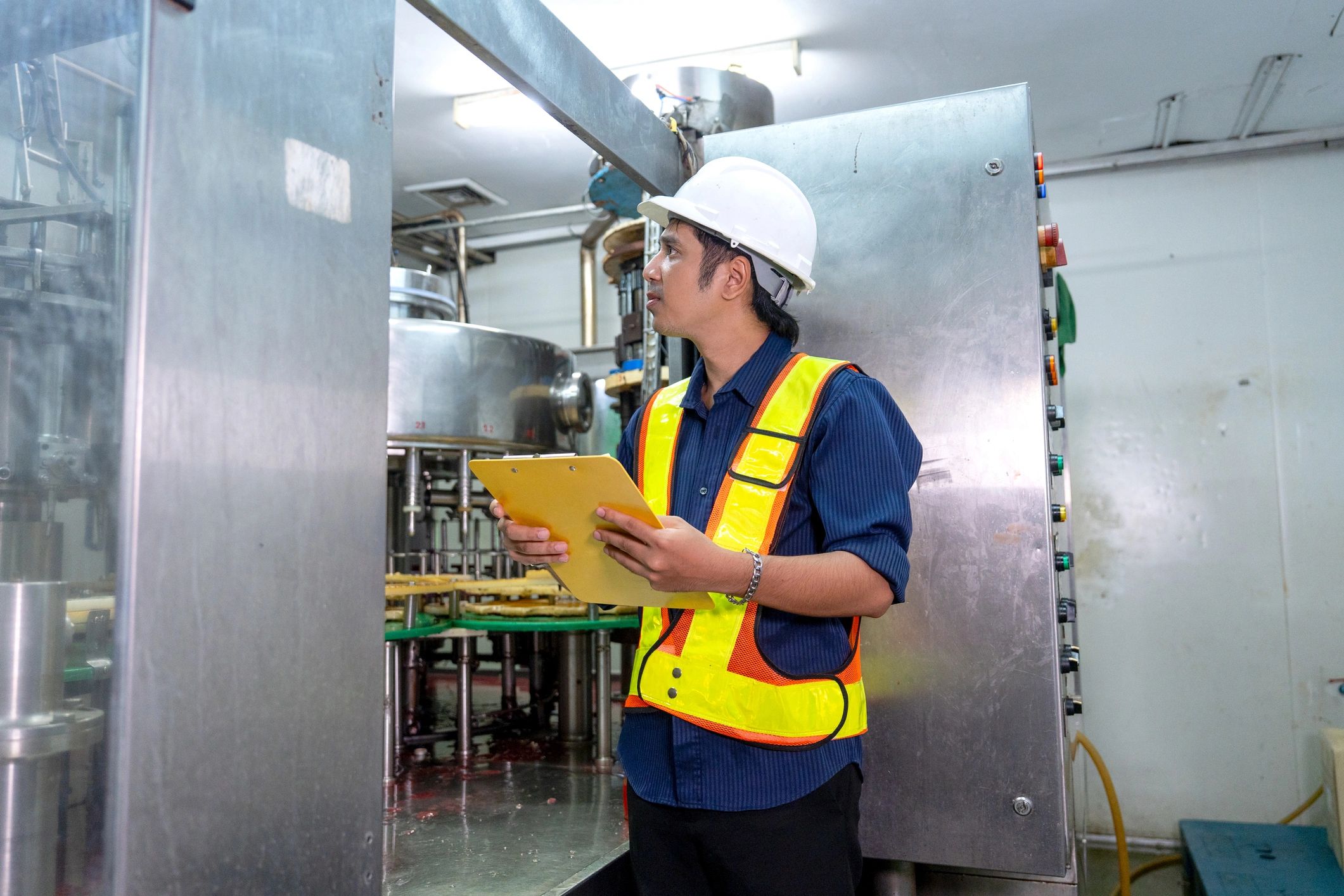Industrial technician inspecting machinery and control systems
